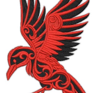 May include: Embroidered raven design in red and black. The raven is shown with outstretched wings, featuring detailed patterns. Suitable for patches, clothing, or decorative items.
