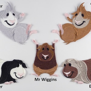 May include: Five embroidered patches of guinea pigs with different coloured fur and facial expressions. The patches are labelled "Tweeter", "Albert", "Mr. Wiggins", "Rumbler", and "Ernie".