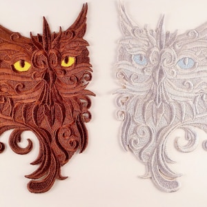 May include: Two embroidered owl patches. One is brown with yellow eyes, the other is white with blue eyes. Both have intricate, swirling details and are suitable for sewing onto fabric.