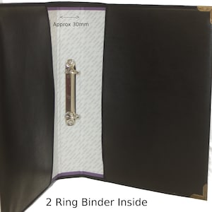 May include: Open black 2-ring binder with a silver metal ring mechanism. The rings are approximately 30mm in diameter. The binder is open to show the inside.