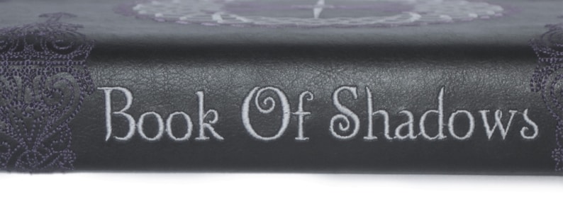 May include: A black leather-bound book with the words "Book of Shadows" embossed in silver lettering.