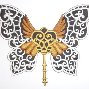 May include: Black and white embroidered butterfly with gold wings and a keyhole heart design.