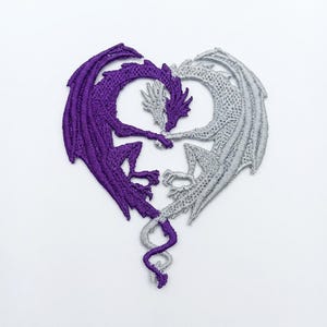 May include: An embroidered patch featuring two dragons, one purple and one silver, positioned to form a heart shape. The dragons face each other with their wings and tails curved to create the outline of a heart, with detailed stitching throughout.