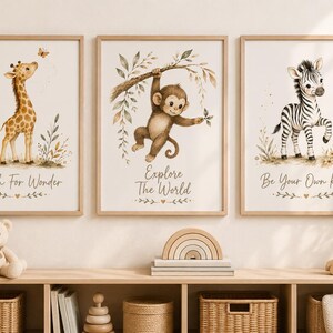 Könnte beinhalten: Drei gerahmte Wandbilder mit Aquarellillustrationen einer Giraffe, eines Affen und eines Zebras. Der Giraffendruck zeigt Reach For Wonder, der Affendruck Explore The World und der Zebradruck Be Your Own Kind.