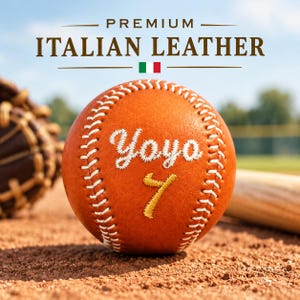 Op de afbeelding: Een beige leren honkbal met witte stiksels, de geborduurde witte tekst Yoyo en een geel geborduurd cijfer 7. Boven de bal staat de tekst PREMIUM ITALIAN LEATHER met een klein icoon van de Italiaanse vlag in het midden.