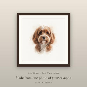 Puede incluir: Una pieza de arte mural cuadrada enmarcada que presenta un retrato en acuarela suave de un perro Cavapoo marrón y blanco. La impresión mide 40 x 40 cm. El texto dice: 40 x 40 cm · Soft Watercolour Made from one photo of your cavapoo OLEA & HOUND.