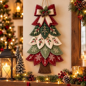 May include: A wall-hanging Christmas tree decoration made of layered, quilted fabric leaves in red, green, and cream. The tree features embroidered snowflake and holly berry patterns, topped with a large red and cream fabric bow and pine cones.