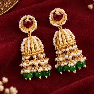 Pendientes tradicionales indios Jhumka, tono dorado con detalles de perlas rojas y verdes.