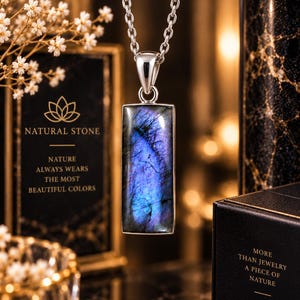 May include: A rectangular labradorite pendant with iridescent blue and purple flashes set in a polished silver frame, suspended from a matching silver chain. The stone displays natural internal fractures and a smooth, reflective surface finish.