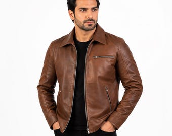 Puede incluir: Una chaqueta de cuero marrón con cuello clásico, cremallera frontal completa y dos bolsillos laterales con cremalleras plateadas. La chaqueta incluye un bolsillo horizontal con cremallera en el pecho izquierdo y mangas largas con puños.