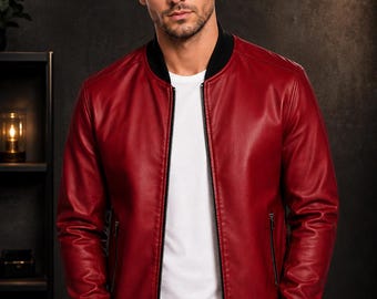 Puede incluir: Una chaqueta tipo bomber de color rojo con cuello acanalado negro, puños acanalados negros y un cierre de cremallera central negro. La chaqueta incluye dos bolsillos laterales con cremalleras negras, sobre una camiseta blanca y pantalones oscuros.