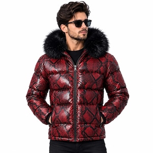 Könnte beinhalten: Eine Steppjacke mit einem leuchtend roten und schwarzen Schlangenmuster, einem durchgehenden Frontreißverschluss und einer Kapuze mit dickem schwarzem Kunstfellbesatz. Die Jacke hat ein gestepptes Design mit horizontalen Kammern.