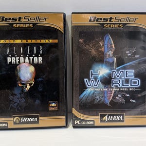 May include: Two PC CD-ROM game cases from the Best Seller Series. The left case is Aliens Versus Predator Gold Edition featuring a skull graphic. The right case is Homeworld, a 3D real-time strategy game, both published by Sierra.
