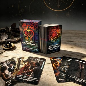 May include: A deck of oracle cards titled What's Blocking You? Singles & Relationship Oracle Deck, featuring a box and a stack of cards with a colorful maze-like heart design. Several individual cards are spread out, displaying photographic imagery and text.