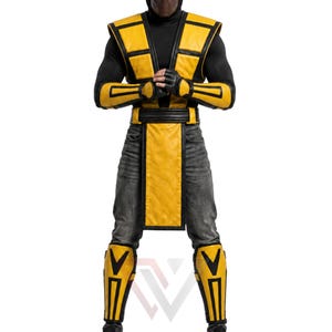 Pode incluir: Um traje amarelo e preto composto por um colete sem mangas com painéis estruturados, protetores de antebraço a condizer, um cinto largo com uma aba frontal comprida e caneleiras. O conjunto é usado sobre uma camisola preta de manga comprida e calças de ganga cinzentas.