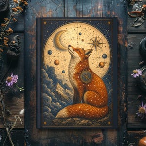 May include: A rectangular hardcover book featuring a vibrant orange fox sitting against a backdrop of a golden celestial map, a crescent moon, and scattered stars. The fox has a circular compass emblem on its side and is positioned above dark clouds.
