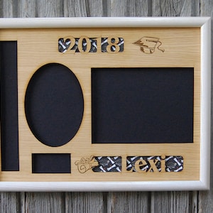 Peut inclure: Un cadre photo de remise de dipl&ocirc;me en bois avec une bordure blanche. Le cadre comporte des espaces pour des photos de diff&eacute;rentes formes, dont un ovale et un rectangle. L'ann&eacute;e "2018", une toque de dipl&ocirc;m&eacute; et le nom "Lexi" sont d&eacute;coup&eacute;s dans le bois.