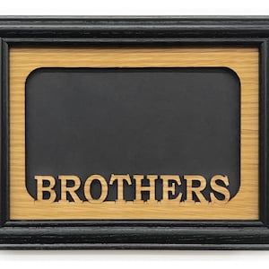 Puede incluir: Un marco de fotos de madera negra con una incrustación de madera que dice "Brothers".