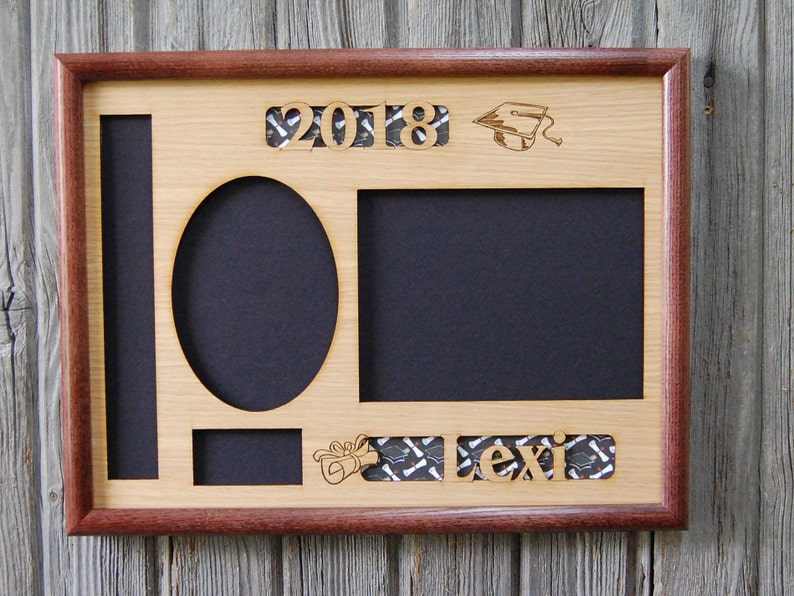 Peut inclure: Cadre photo de graduation en bois avec un int&eacute;rieur en bois clair et une bordure en bois fonc&eacute;. Le cadre comporte des d&eacute;coupes pour les photos, l'ann&eacute;e "2018", une toque de dipl&ocirc;m&eacute; et le nom "Lexi". Le fond des d&eacute;coupes est un tissu &agrave; motifs.