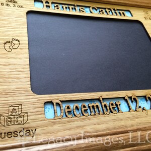 May include: A wooden picture frame with a blue and white patterned mat. The frame is engraved with the text "Harris Catlin", "December 12, 2017", "Tuesday", "6 lb. 3 oz.", "21.5 in", and "A B C".