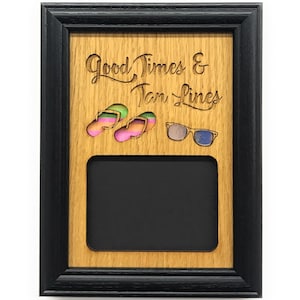 Puede incluir: Un marco de fotos de madera con un borde negro. El marco tiene un diseño recortado de chanclas, gafas de sol y el texto "Good Times & Tan Lines".