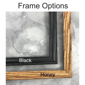 May include: Two rectangular picture frames labeled Frame Options. One frame is black with a visible wood grain texture, and the other is a honey-colored wood frame with a natural grain pattern. The text Black and Honey labels each frame.