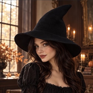 May include: A solid black pointed hat with a wide, slightly curved brim. The hat features a textured, knit-like surface and a tall, conical crown that tapers to a rounded point at the top. The design is simple, featuring a uniform dark color.