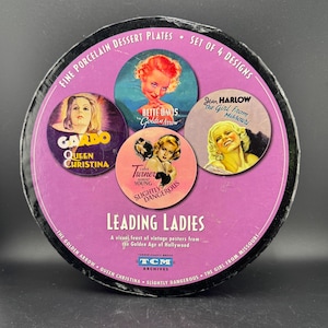 Peut inclure: Ensemble de quatre assiettes à dessert en porcelaine fine représentant des affiches de films vintage de l'âge d'or d'Hollywood. Les assiettes présentent des images de Bette Davis dans "Golden Arrow", Jean Harlow dans "The Girl from Missouri", Greta Garbo dans "Queen Christina" et Lana Turner dans "Slightly Dangerous".