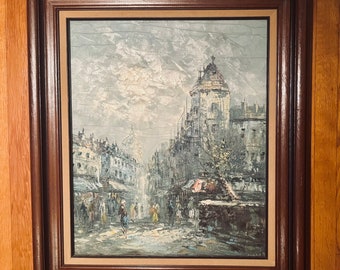 Könnte beinhalten: Ein gerahmtes Ölgemälde, das eine europäische Stadtstraße mit Gebäuden, einem bewölkten Himmel und Fußgängern zeigt. Das Gemälde ist in einem dunkelbraunen Rahmen mit goldener Verzierung.