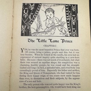 May include: A black and white illustration from "The Little Lame Prince" book. The image depicts a baby in a decorated bed, with text below. The baby is the central focus, rendered in a detailed drawing style.