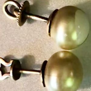 Peut inclure: Une paire de boucles d'oreilles en perles avec des tiges et des dos en or. Les perles sont rondes et blanches.