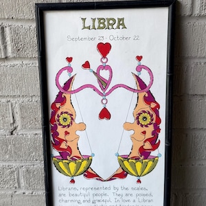 Peut inclure: Impression d'art encadrée du signe du zodiaque Balance. L'œuvre présente une illustration colorée du symbole de la Balance, avec le texte "LIBRA" en haut et les dates du 23 septembre au 22 octobre. L'image comprend des cœurs et des figures stylisées.