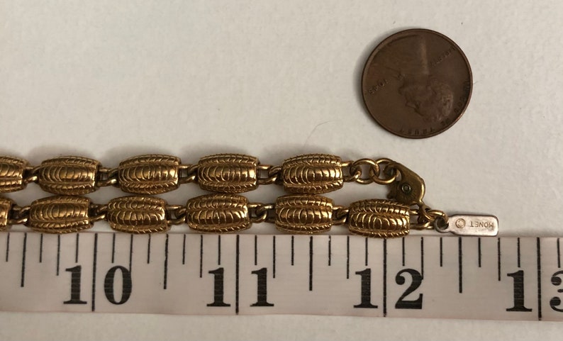 May include: Gold tone chain necklace with a textured oval link design. The necklace is 11 inches long and has a lobster clasp closure. The chain is marked "ROBERT".