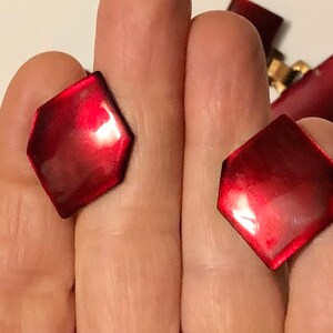Peut inclure: Deux boutons hexagonaux de couleur rouge avec une finition brillante.