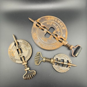 May include: Three antique cast iron stovepipe dampers. The largest damper is 15 cm in diameter and reads "Griswold Erie Pa. New American 6 in.". The other two dampers are smaller and read "Reversible Steel Spindle 4 in." and "Reversible Steel Spindle 6 in."