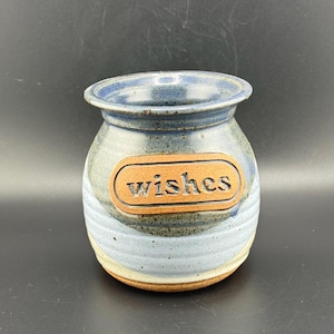 May include: A blue and white ceramic jar with a brown label that says "wishes".