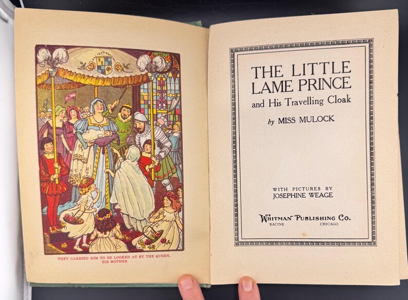May include: An open book featuring a vibrant illustration of a royal court on the left page. The right page displays the title "THE LITTLE LAME PRINCE" and author details. The book is published by Whitman Publishing Co.