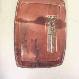 May include: A rectangular ceramic dish with a brown glaze and a white design of bamboo stalks and leaves.