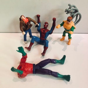 May include: A set of four action figures, including Spider-Man, Doc Ock, and two other characters. The figures are made of plastic and are in good condition. The figures are all in different poses and are ready for action.