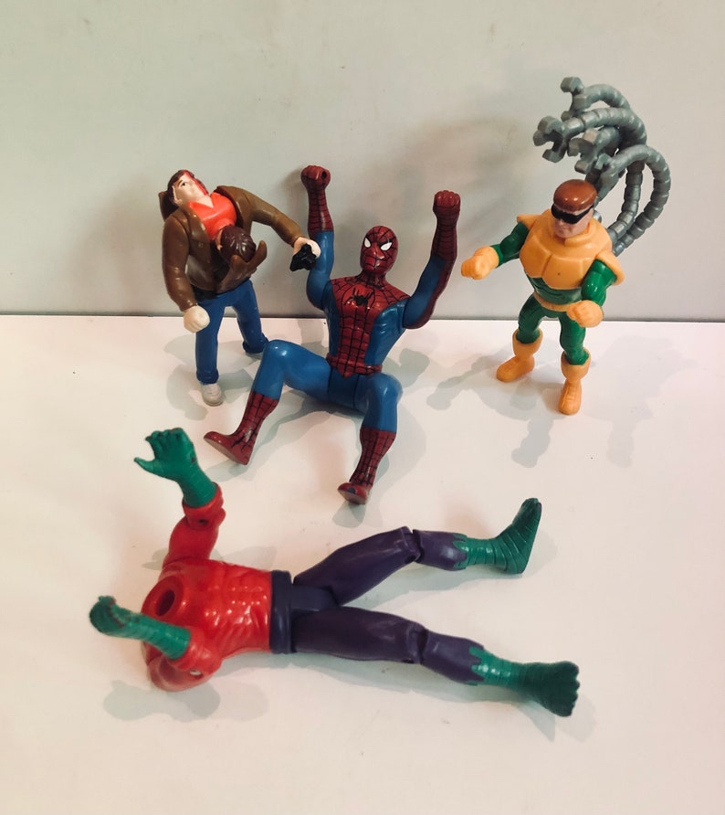 May include: A set of four action figures, including Spider-Man, Doc Ock, and two other characters. The figures are made of plastic and are in good condition. The figures are all in different poses and are ready for action.