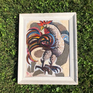 Peut inclure: Une peinture encadrée d'un coq avec une queue colorée et un corps blanc. Le coq est peint dans un style mosaïque avec des morceaux de papier ou de tissu de différentes couleurs.