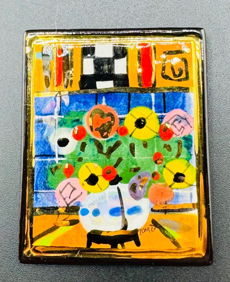 May include: A colorful, abstract painting of a vase of flowers in a gold frame. The flowers are red, yellow, and pink, and the vase is white with blue accents. The background is a blue and green tiled wall. The painting is signed "Tume" in the lower right corner.