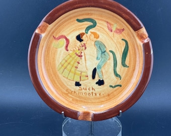 Cenicero de cerámica vintage de Pennsbury Pottery con la imagen de una pareja amish besándose, arte popular holandés de Pensilvania. Tal cual (pequeña muesca en el borde).