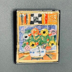 May include: A colorful ceramic tile with a mosaic design featuring a vase with flowers, a checkered pattern, and the signature "KATE" in the bottom right corner.