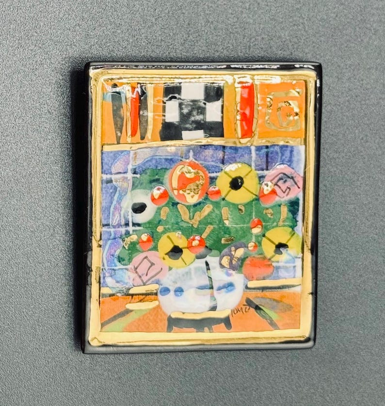May include: A colorful ceramic tile with a mosaic design featuring a vase with flowers, a checkered pattern, and the signature "KATE" in the bottom right corner.