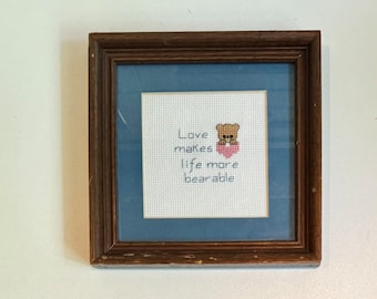 Adorable Vintage Framed Cross Stitch Wall Art “Love makes life more bearable” Small Anthropomorphic Teddy Bear Holding Pink Heart