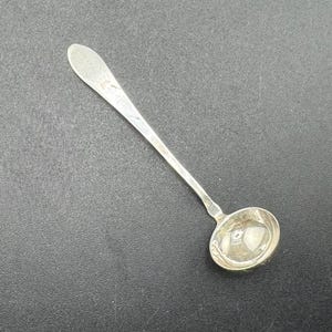 May include: A whimsical, cartoon-style illustration of a smiling, anthropomorphic avocado character. The avocado has a large, green body, a brown pit, and is wearing a chef's hat. The background is plain white.