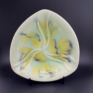 May include: A triangular ceramic dish with a light green glaze and yellow and black marbling. The dish has three sections.