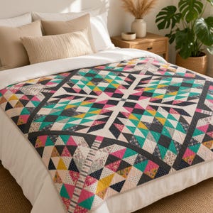 May include: A quilt featuring a geometric pattern of triangles in shades of teal, mustard yellow, dark charcoal, and pink, accented with small floral and polka dot prints. The quilt is spread across a bed with white and beige pillows.