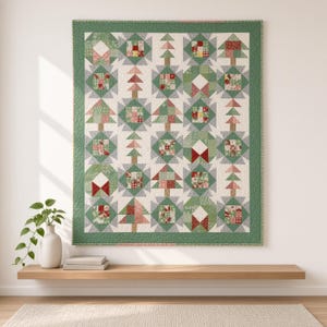 May include: A rectangular quilt featuring a repeating pattern of stylized Christmas trees and geometric blocks in shades of green, red, and white. The quilt is framed by a solid green border and displays a variety of festive fabric prints.